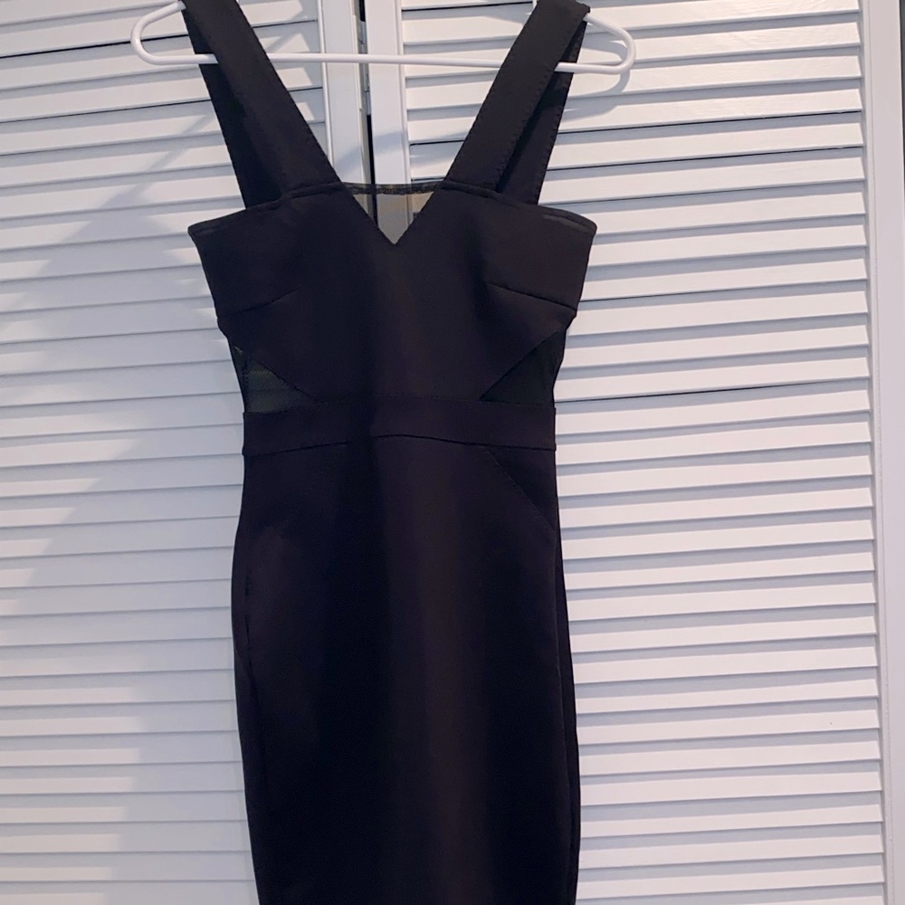Black dress with mesh cut outs on top and sides. Zips in back.